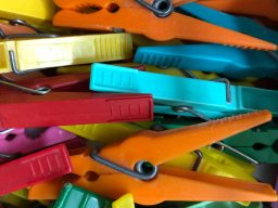 Bunte Wäscheklammern in verschiedenen Farben liegen durcheinander.