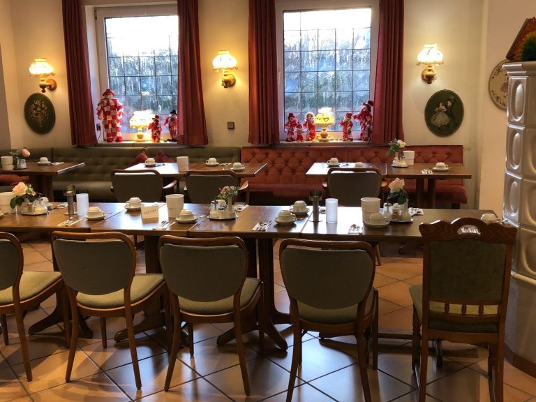 Ein eleganter Speisesaal mit gedeckten Tischen und Fensterblick auf den Außenbereich.