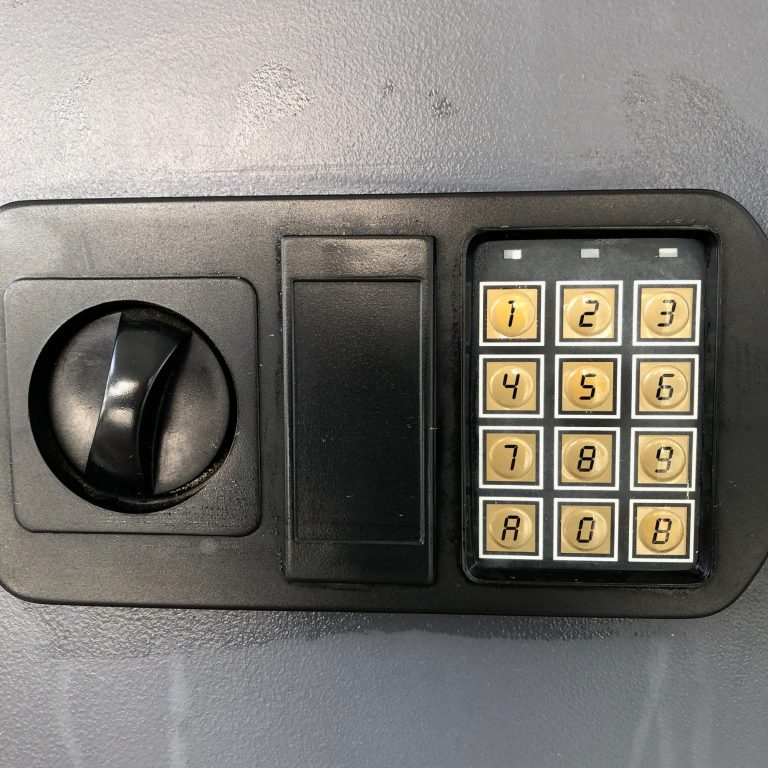 Safe mit Tastatur und einem Finger, der eine Taste berührt -Schlüsseltresor für individuelle Anreise