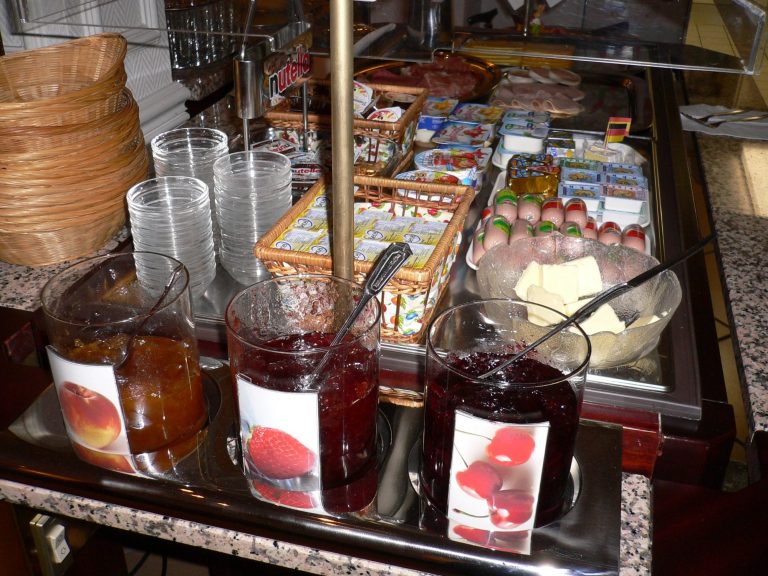 Ein Frühstückstisch mit Marmeladen, Aufstrichen und Getränken.